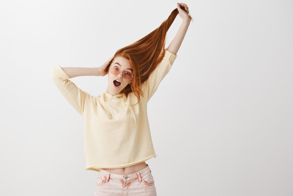 mujer mostrando feliz su cabello sin frizz