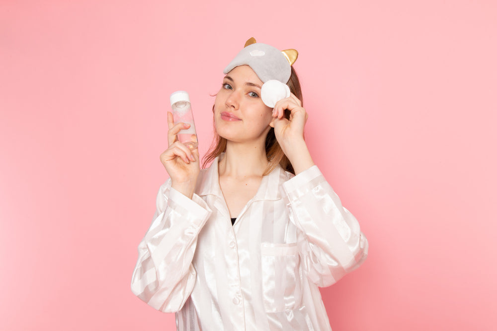 Una chica preparándose para su skincare que incluye una crema de noche, desmaquillarse y una loción para su cutis