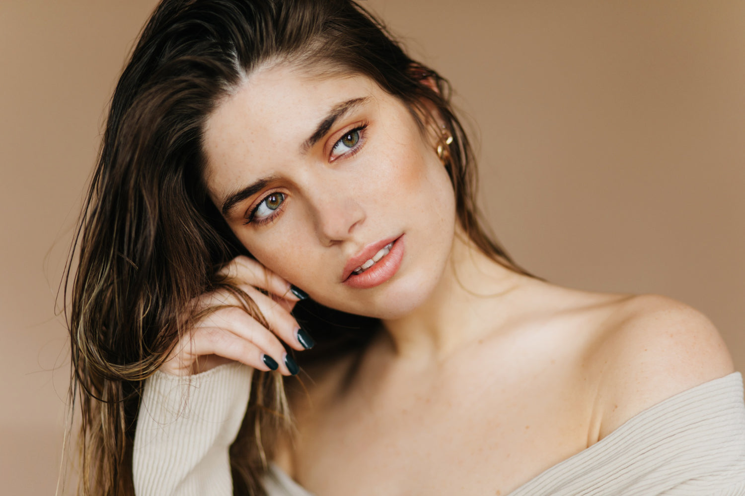 modelo joven en una sesión con un fondo color piel mostrando el cuidado de sus uñas como reina por seguir 10 tips