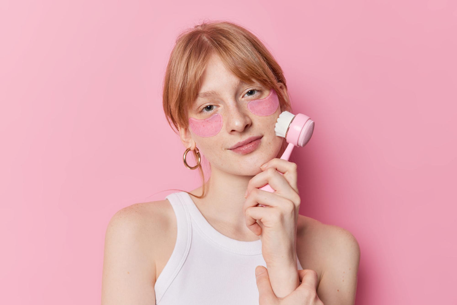 una chica pelirroja que empieza una nueva rutina de skincare con OnPost Beauty con cepillitio en su mano y tratamiento facial