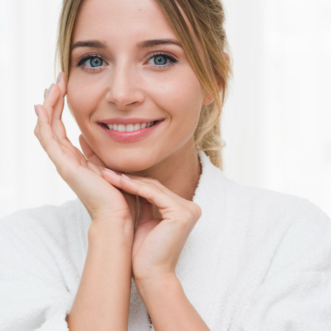 Mujer joven mostrando su rostro después de un tratamiento facial de microdermoabrasión donde luce feliz