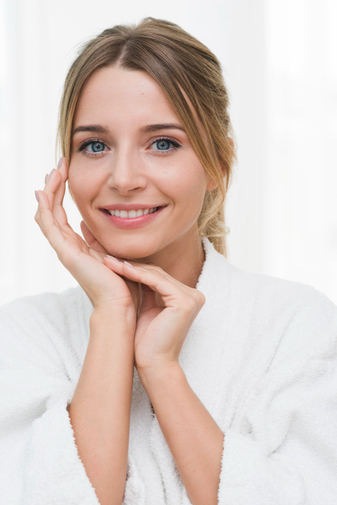 Mujer joven mostrando su rostro después de un tratamiento facial de microdermoabrasión donde luce feliz