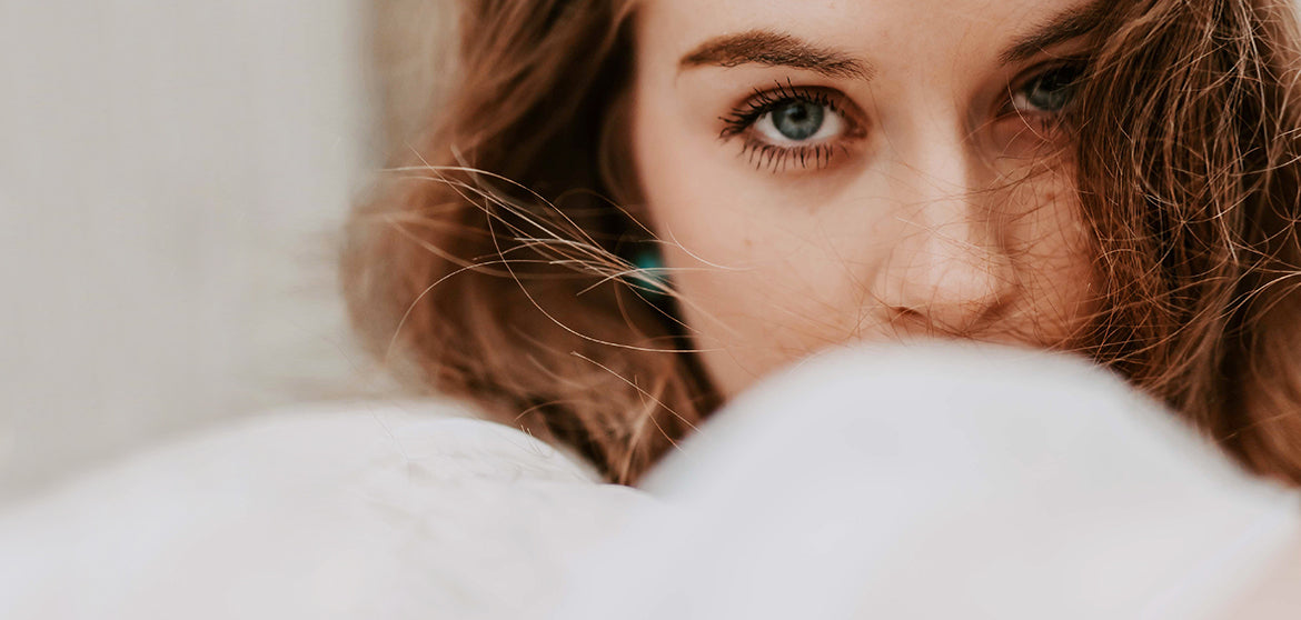 mujer blanca de ojo azules y pelo castaño viendo de frente con un contorno de ojos cuidado