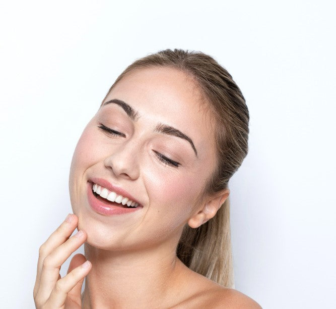 modelo de tez blanca con las manos acariciando su roto después de una aplicación de ácido láctico